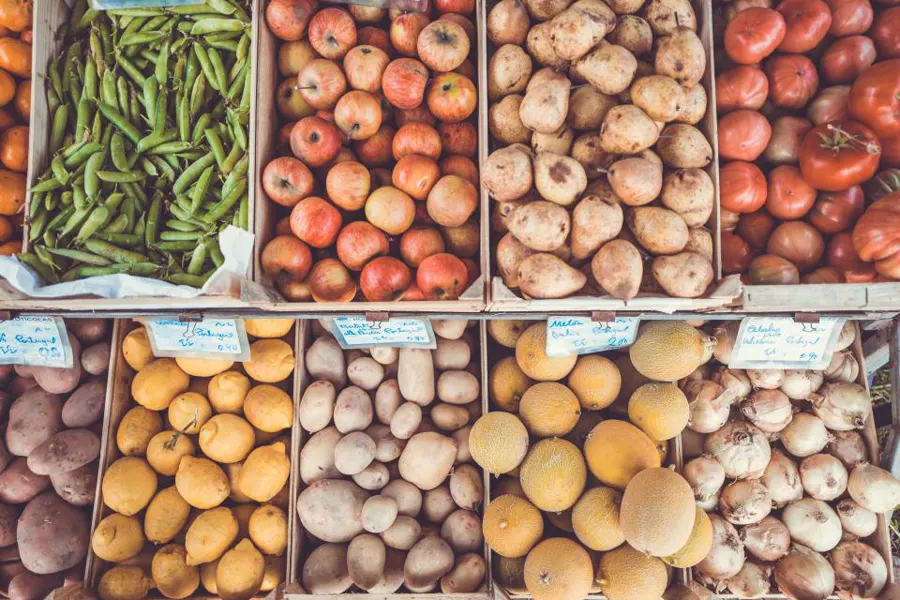 Caixas de feira com legumes, batatas e frutas