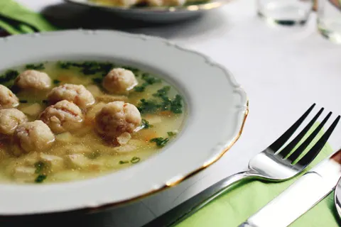Prato fundo de sopa com legumes e almôndegas sobre a mesa